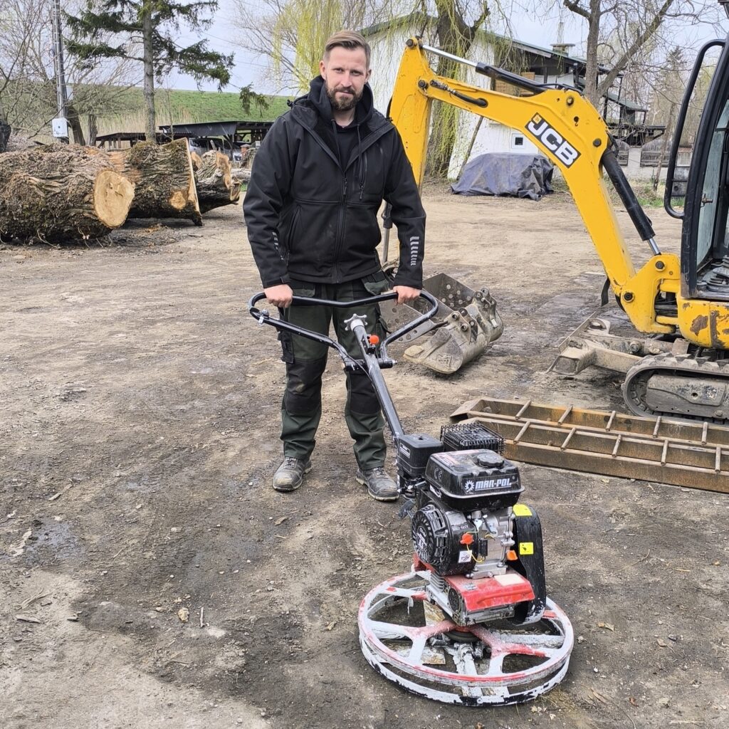 Spalinowa zacieraczka do betonu podczas wygładzania świeżej wylewki w hali w Sandomierzu.