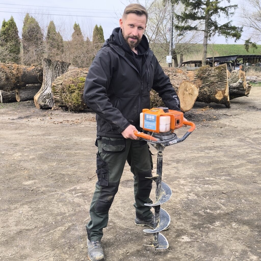 Spalinowy świder glebowy gotowy do wiercenia otworów pod ogrodzenie na posesji w Stalowej Woli.