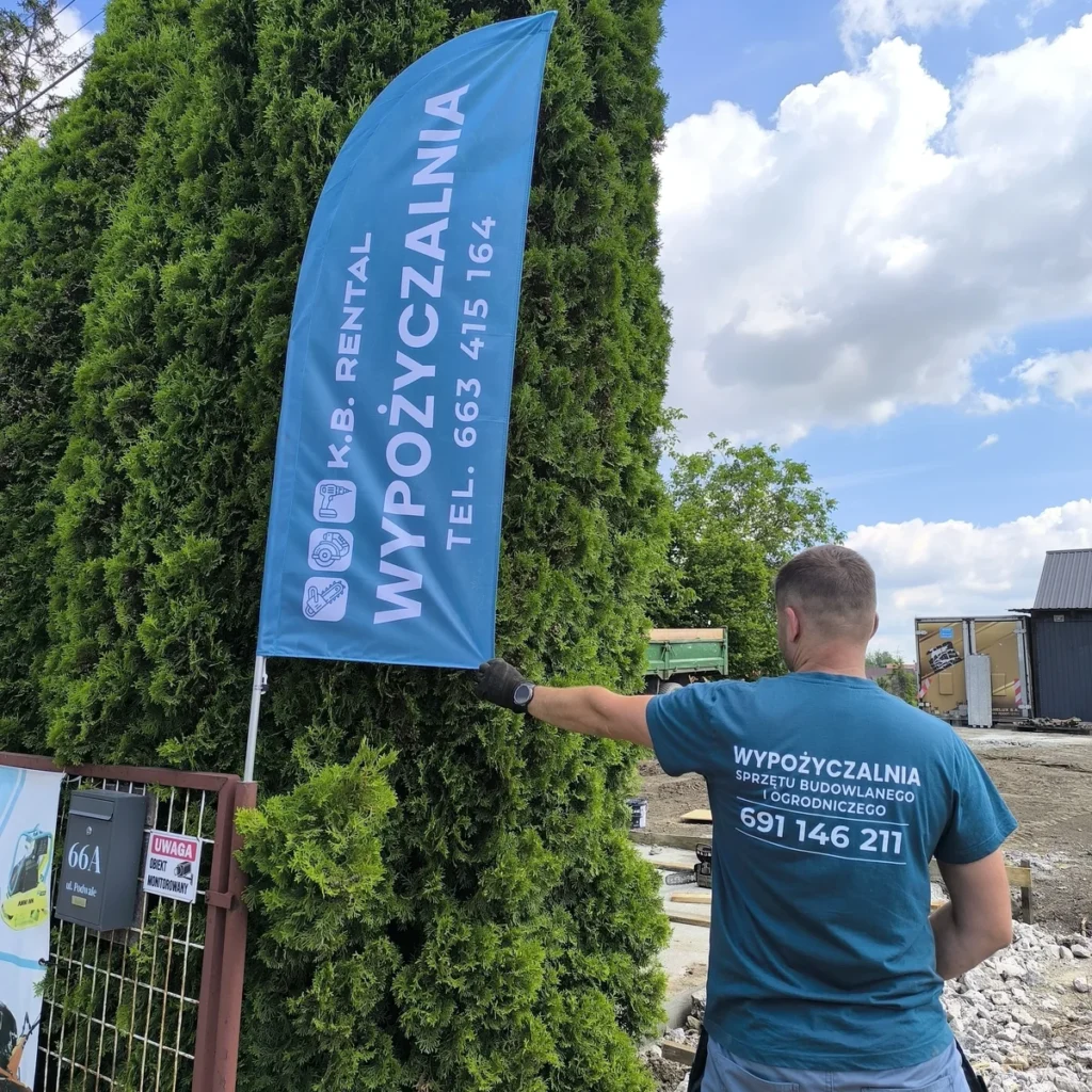Niebieska flaga reklamowa K.B. Rental – wypożyczalni sprzętu budowlanego i ogrodniczego